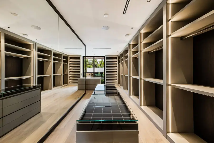 Primary closet with lit oak shelving