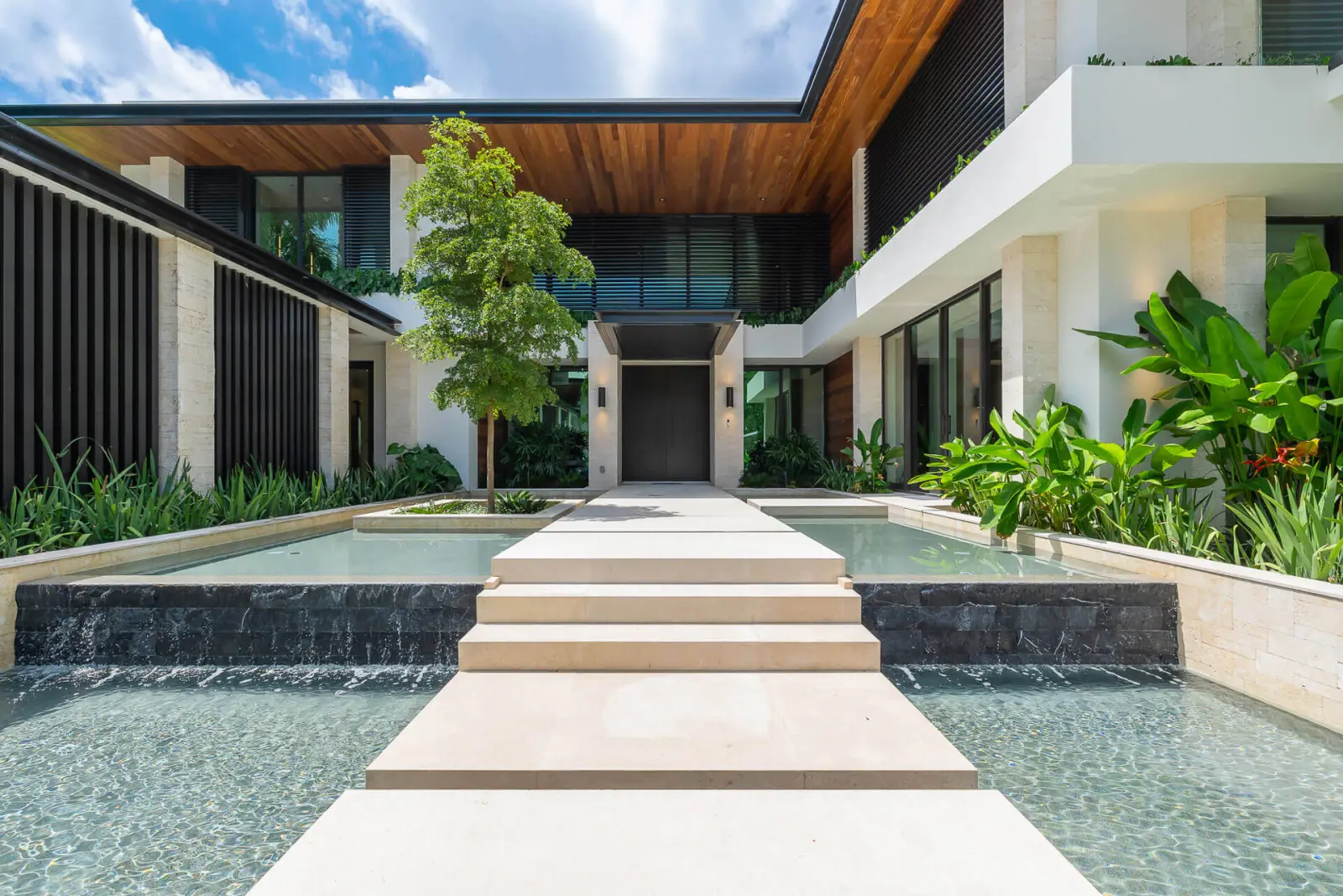 Entry court with floating travertine steps between two reflecting pools